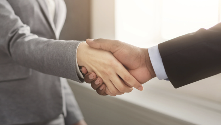 Two business professionals shaking hands to symbolize trust and long-term partnership